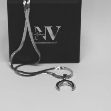 שרשרת לונה כסף עם תליון חצי ירח מונחת על קופסת תכשיטים