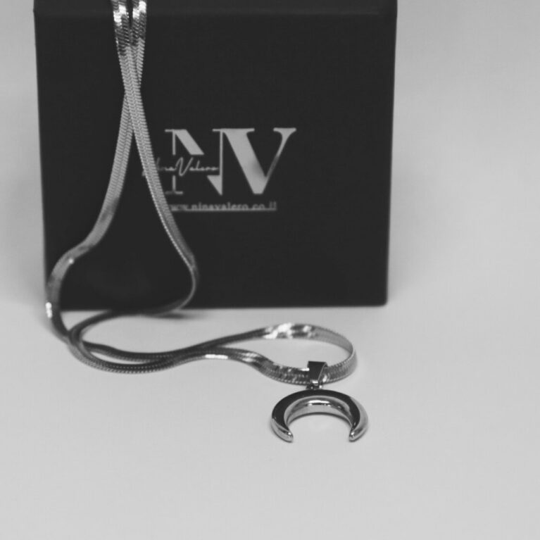 שרשרת לונה כסף עם תליון חצי ירח מונחת על קופסת תכשיטים